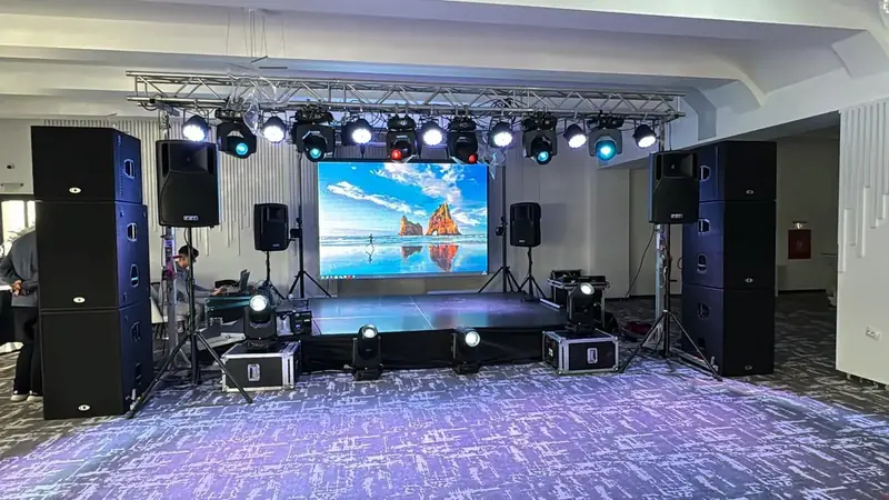 Scenă eveniment cu ecran LED mare, lumini profesionale pe schelă și boxe FBT