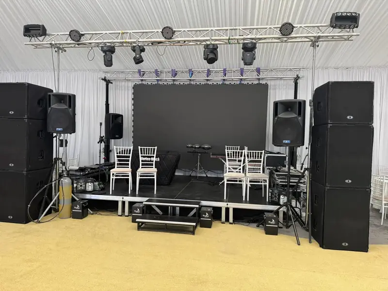 Setup scenă eveniment în cort cu ecran LED oprit, schelă de lumini și sistem PA complet
