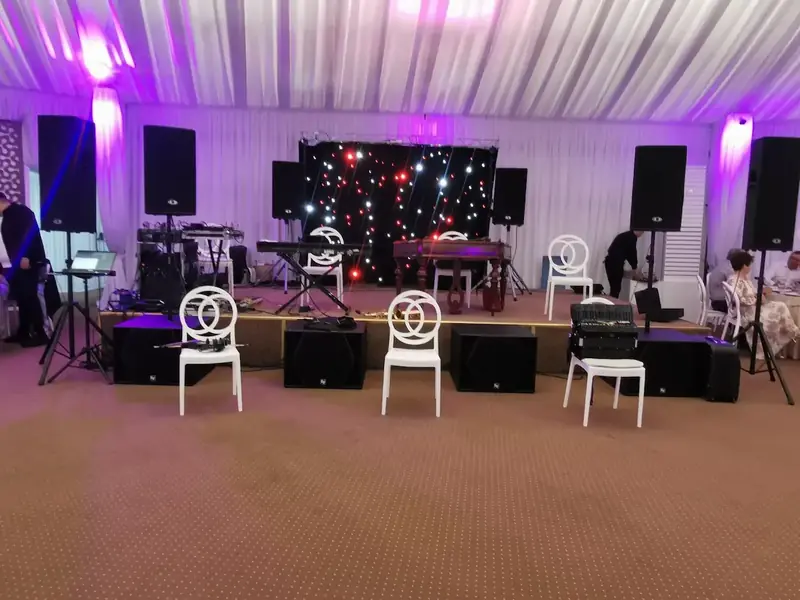 Setup scenă complet pentru formație live cu subwoofere, boxe și ecran LED